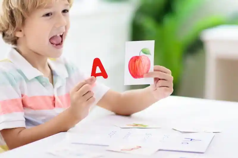Young boy working on reading skills during tutoring session